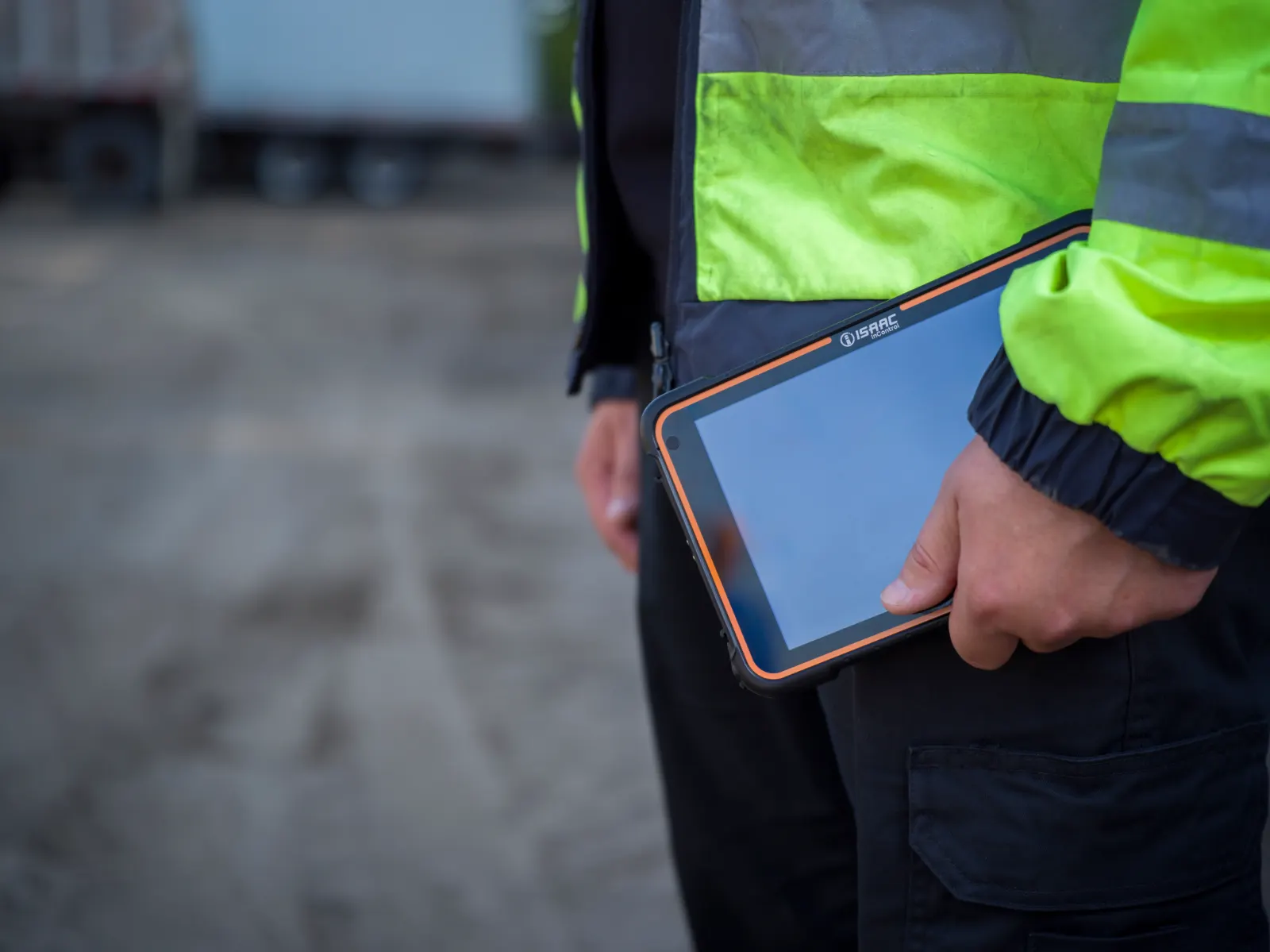 A driver holding the rugged ISAAC in-cab tablet